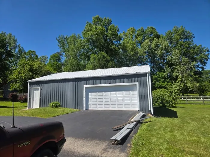 Metal garage repainted charcoal gray with white trim