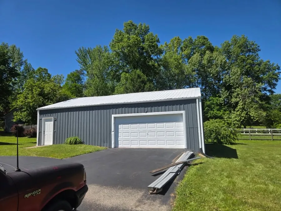 Same metal garage after painting, charcoal gray with white trim