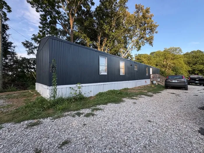 Mobile home repainted navy with white skirting